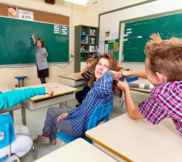 Illustrasjonsbilde av en elev som drar en annen elev i håret i et klasserom.
