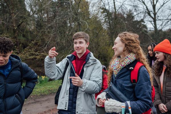 Bilde av fire elever som er på skoletur med en lærer, utendørs.