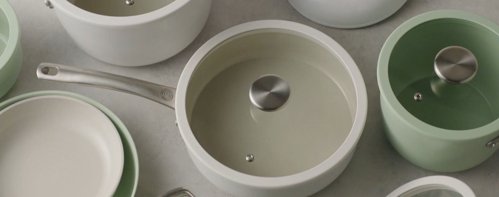 Circulon Ceramic cookware in cream and sage on a stone counter
