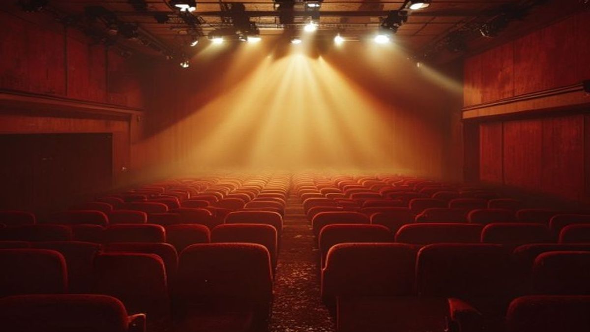 Sala de cine vacía con el haz del proyector iluminando una pantalla con un campo dorado