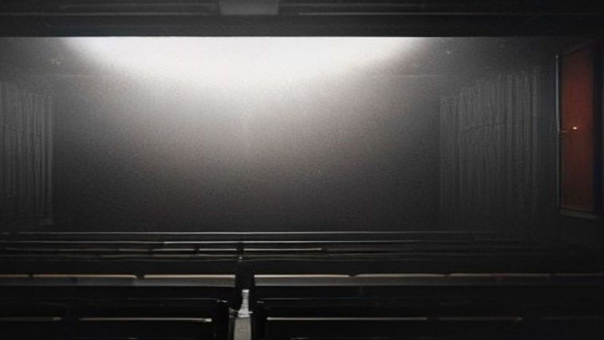 Proyector de cine iluminando una pantalla en una sala oscura, atmósfera cinematográfica