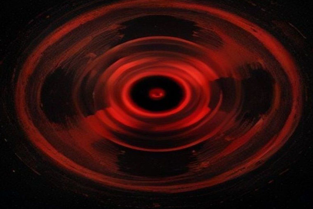 Tres luces anaranjadas girando en un vacío negro infinito, horror cósmico