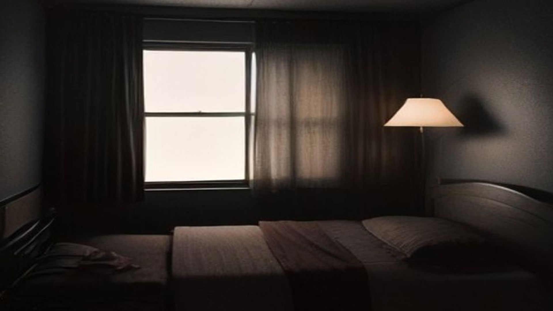 Un rifle de francotirador y páginas de un manuscrito sobre la cama de un motel con luz tenue