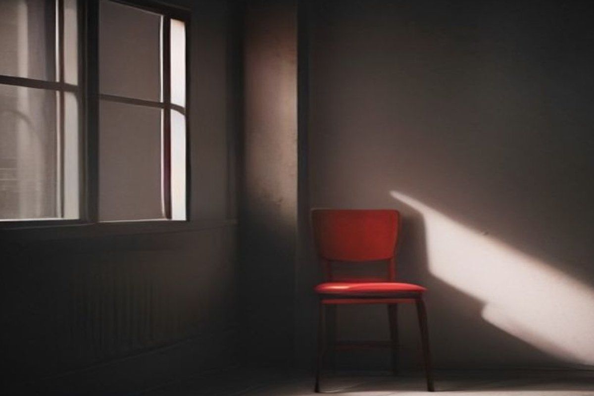 Puerta cerrada vista desde adentro de una habitación en penumbra, con una línea de luz por debajo y una silla contra la pared