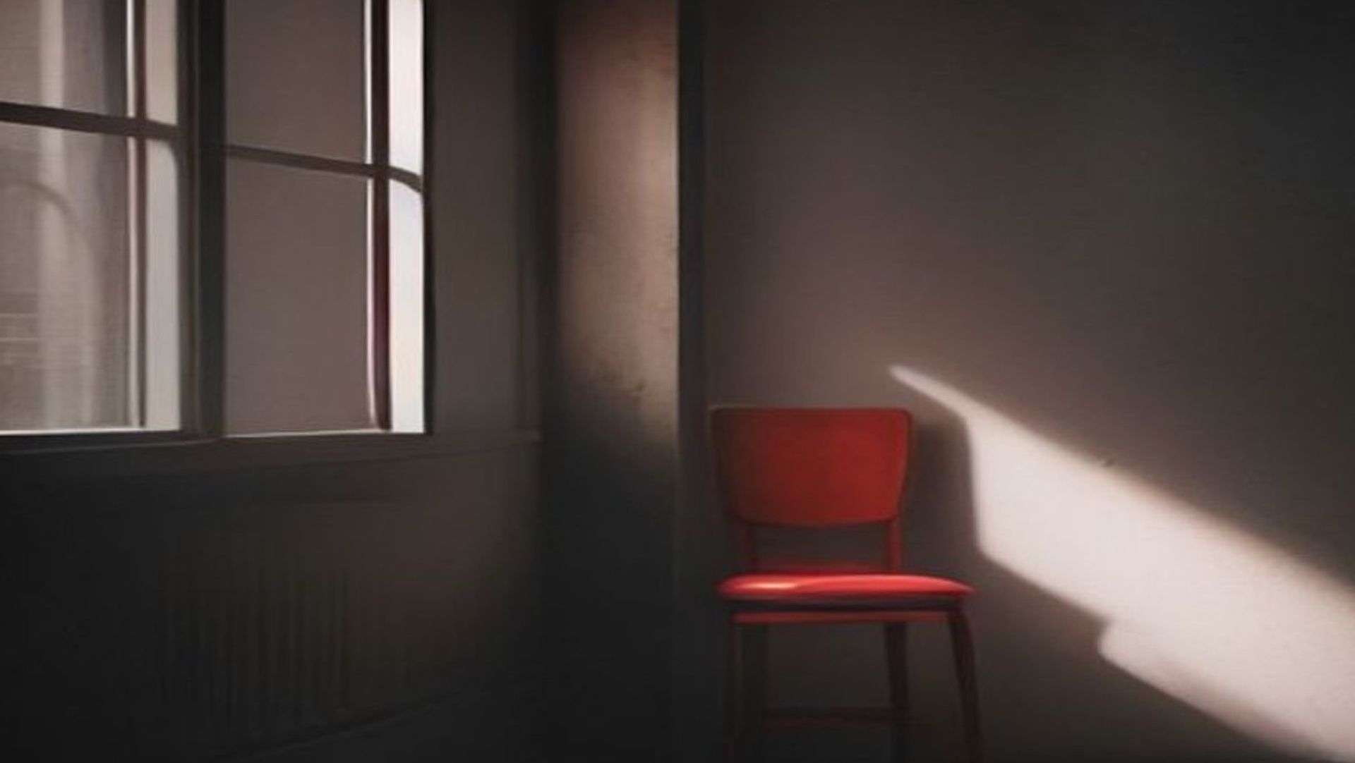 Puerta cerrada vista desde adentro de una habitación en penumbra, con una línea de luz por debajo y una silla contra la pared
