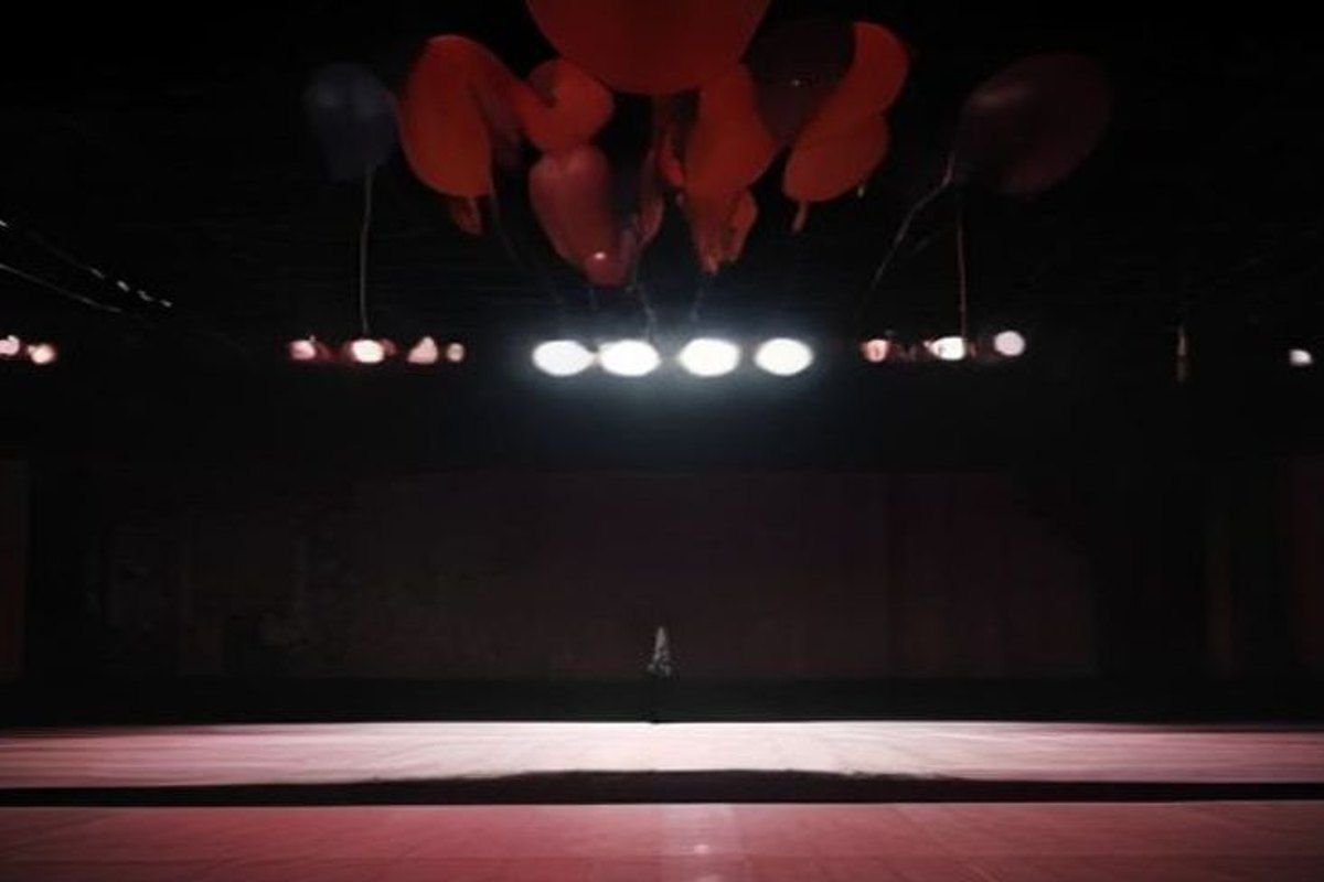 Gimnasio de baile de graduación decorado con serpentinas, atmósfera ominosa con energía telequinética