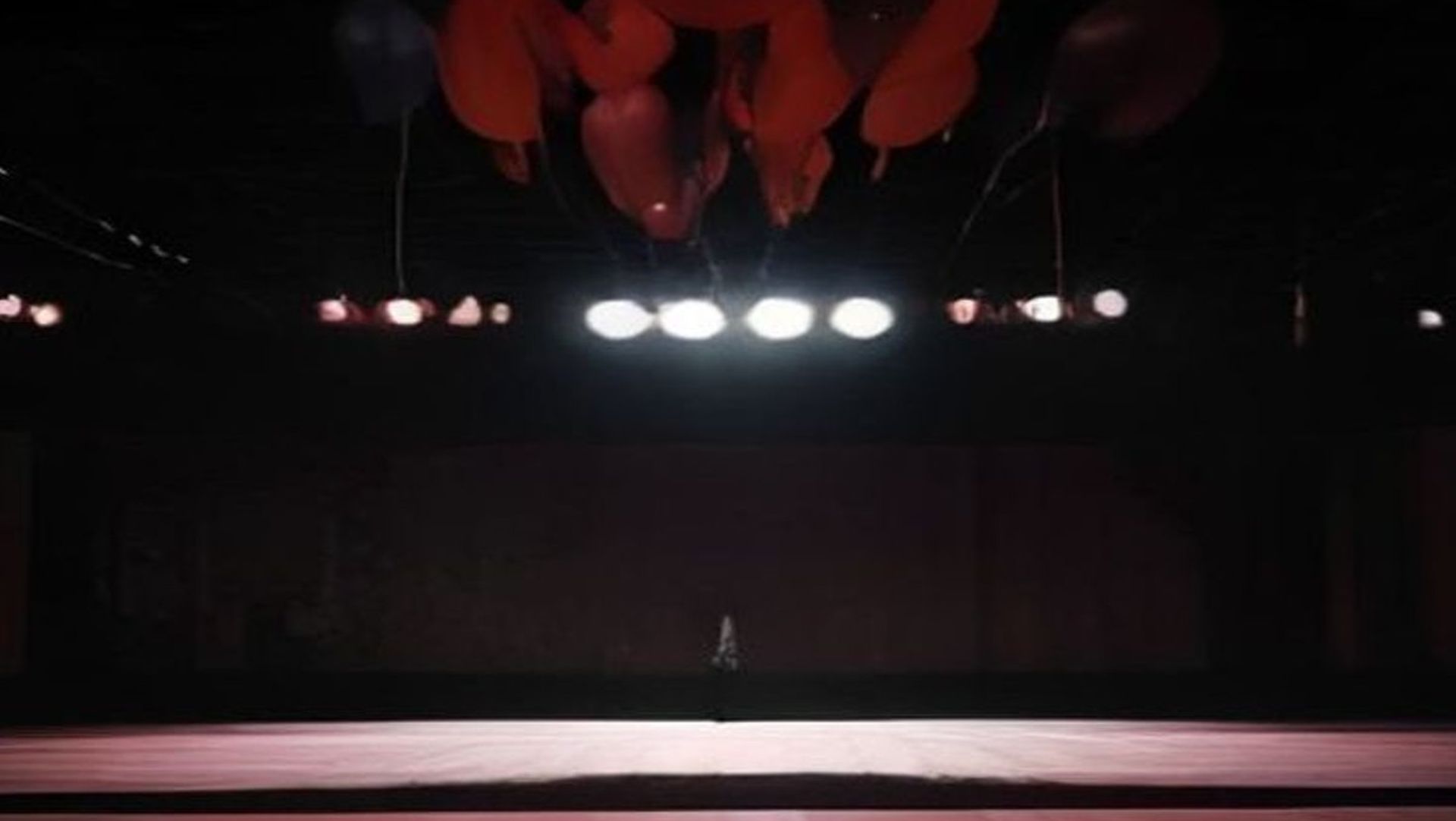 Gimnasio de baile de graduación decorado con serpentinas, atmósfera ominosa con energía telequinética