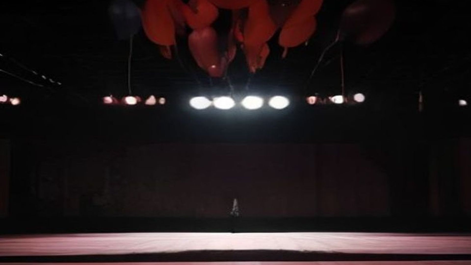 Gimnasio de baile de graduación decorado con serpentinas, atmósfera ominosa con energía telequinética