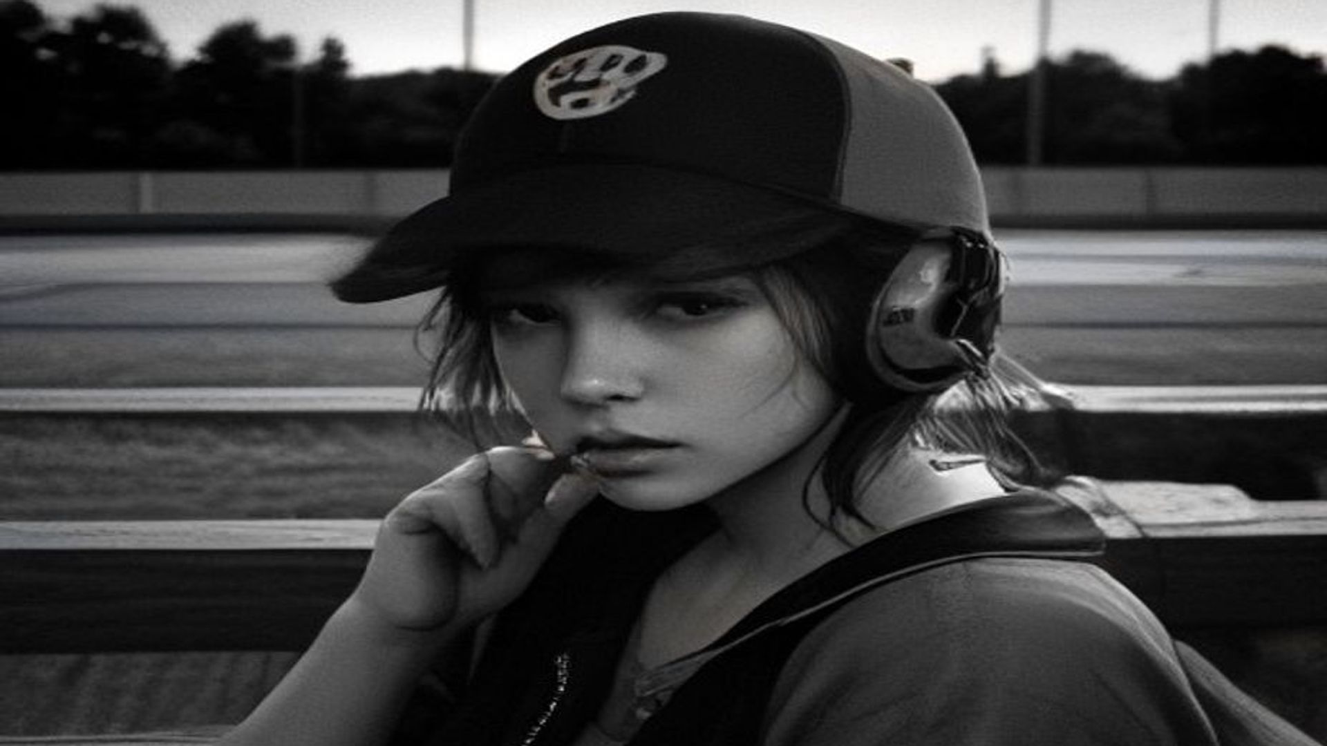 Radio a transistores con auriculares sobre un banco de madera en un dugout vacío al atardecer, junto a una gorra de béisbol gastada