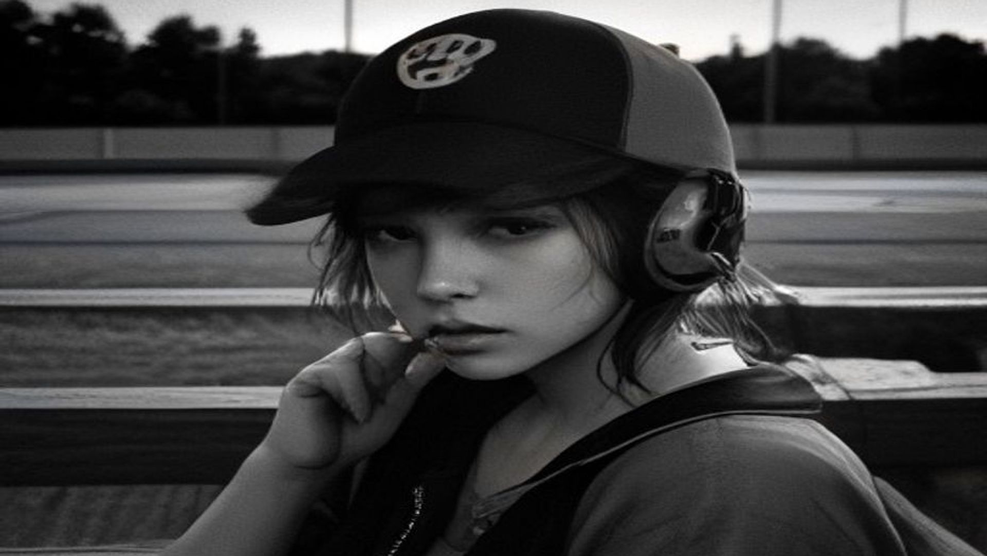 Radio a transistores con auriculares sobre un banco de madera en un dugout vacío al atardecer, junto a una gorra de béisbol gastada