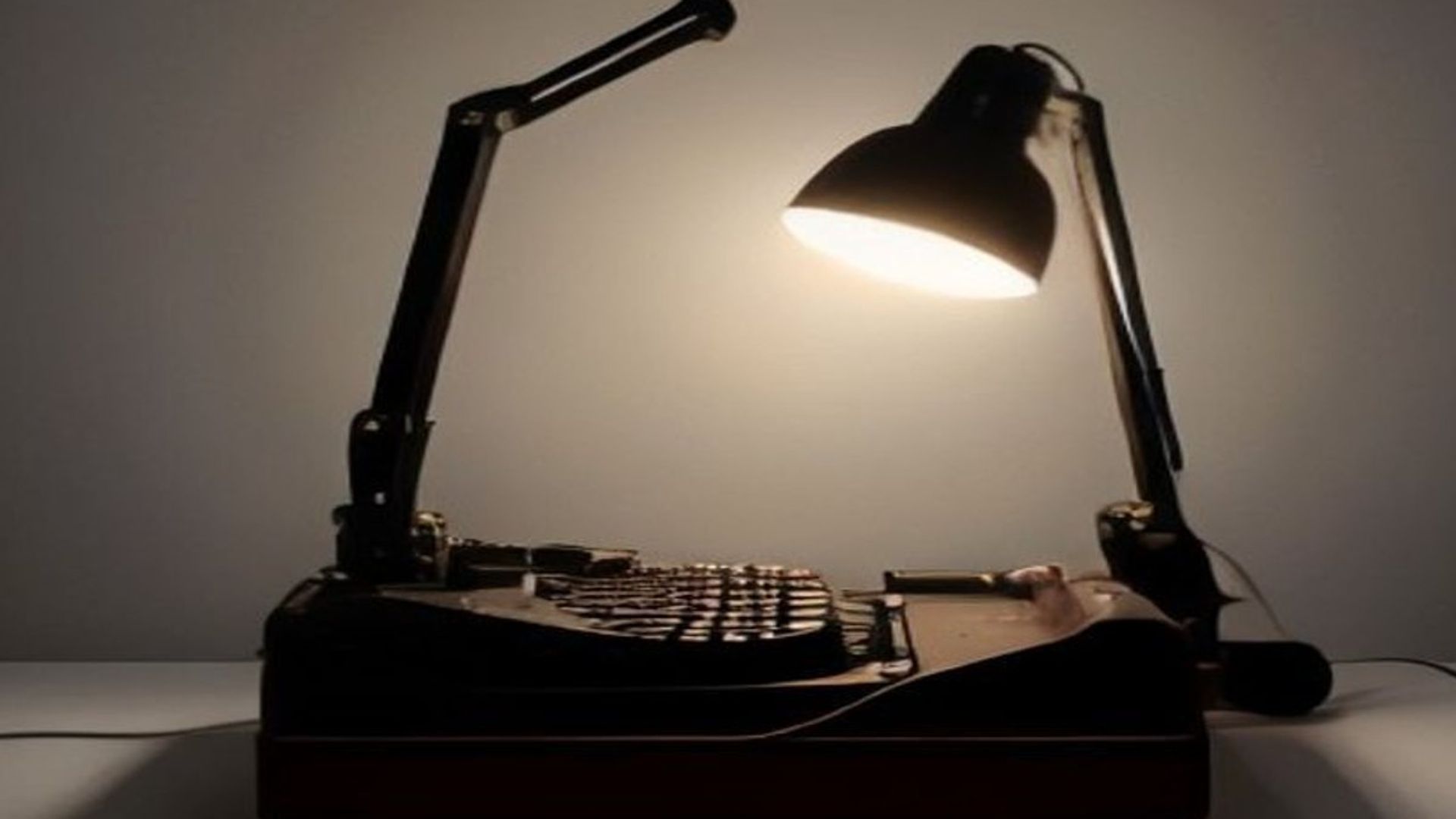 Una máquina de escribir en un estudio a oscuras, con una figura doble y sombría acechando detrás de la silla vacía del escritor