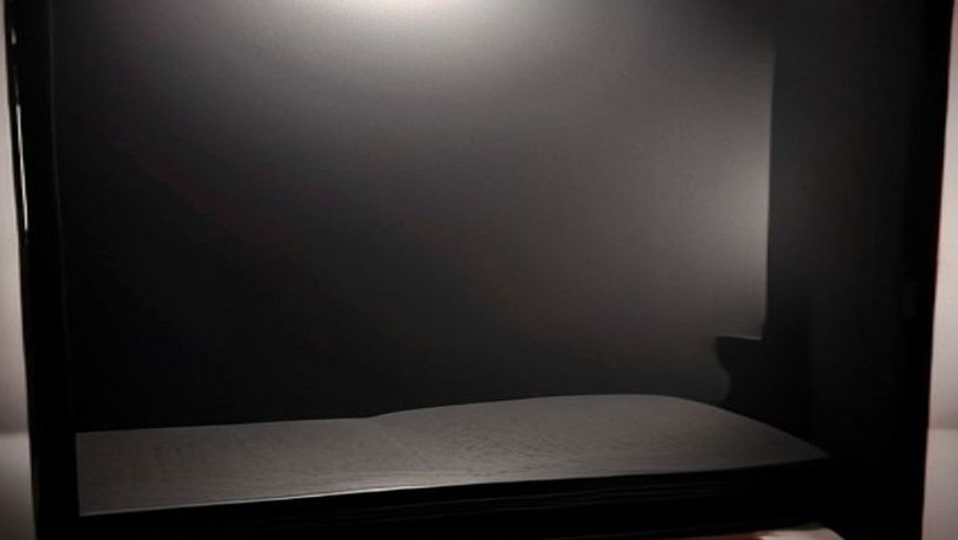 Un libro misterioso con páginas iluminadas sobre un escritorio oscuro rodeado de manuscritos