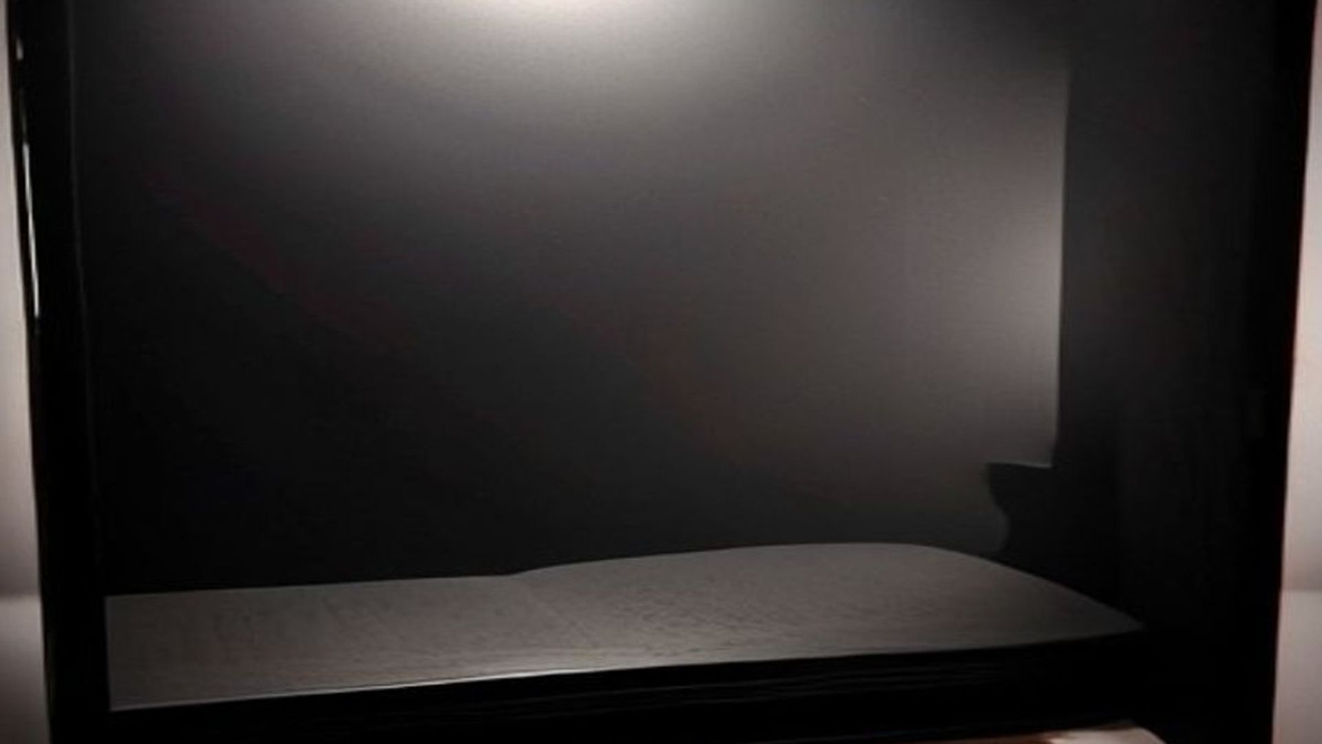 Un libro misterioso con páginas iluminadas sobre un escritorio oscuro rodeado de manuscritos