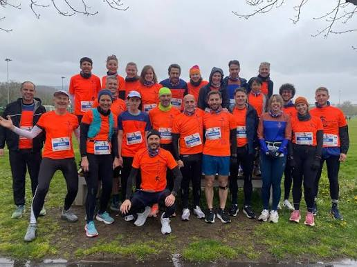 The Dragons race team in orange shirts before a race