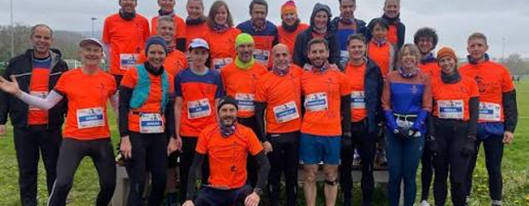 The Dragons race team in orange shirts before a race