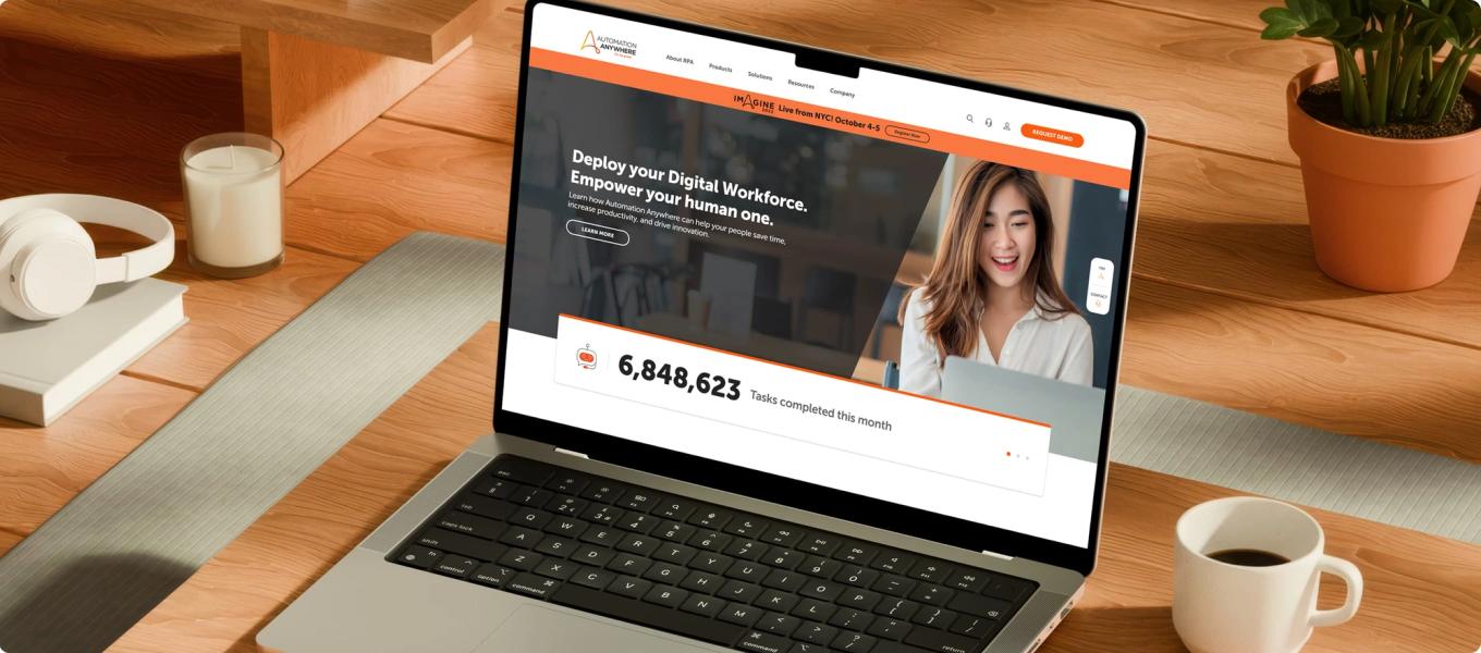 Laptop displaying the Automation Anywhere homepage with a digital workforce headline and tasks completed counter.
