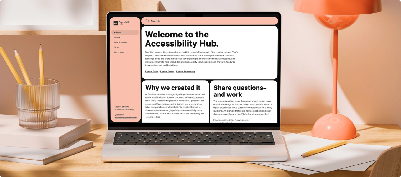 A laptop on a desktop, on the screen you can see the front page of the Accessibility Hub.