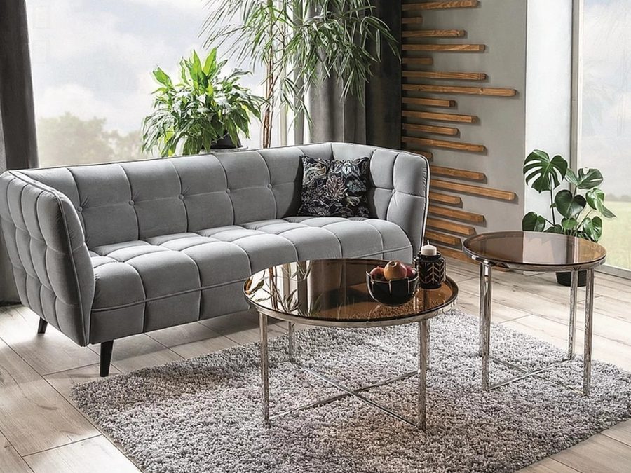 Szara pikowana sofa Castello Velvet 2 marki Signal w aranżacji salonu ze stolikami