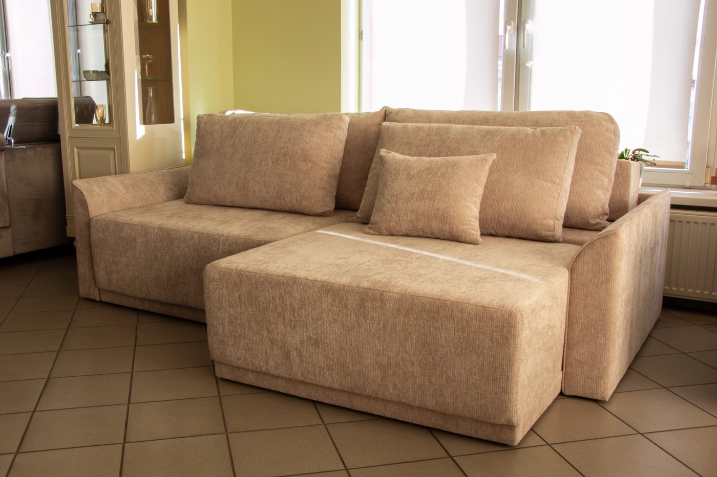 Beżowa sofa z leżanką w salonie meblowym PAKAR w Białymstoku.