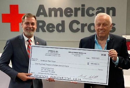 Two men holding a big check 