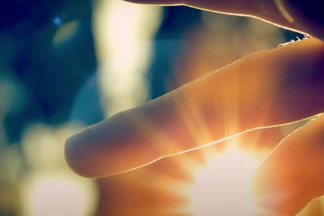 Sunlight peering through human fingers 