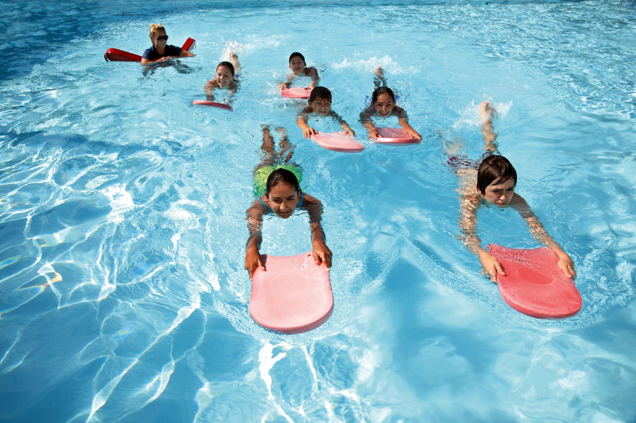 Children with kickboards during a swimming lesson