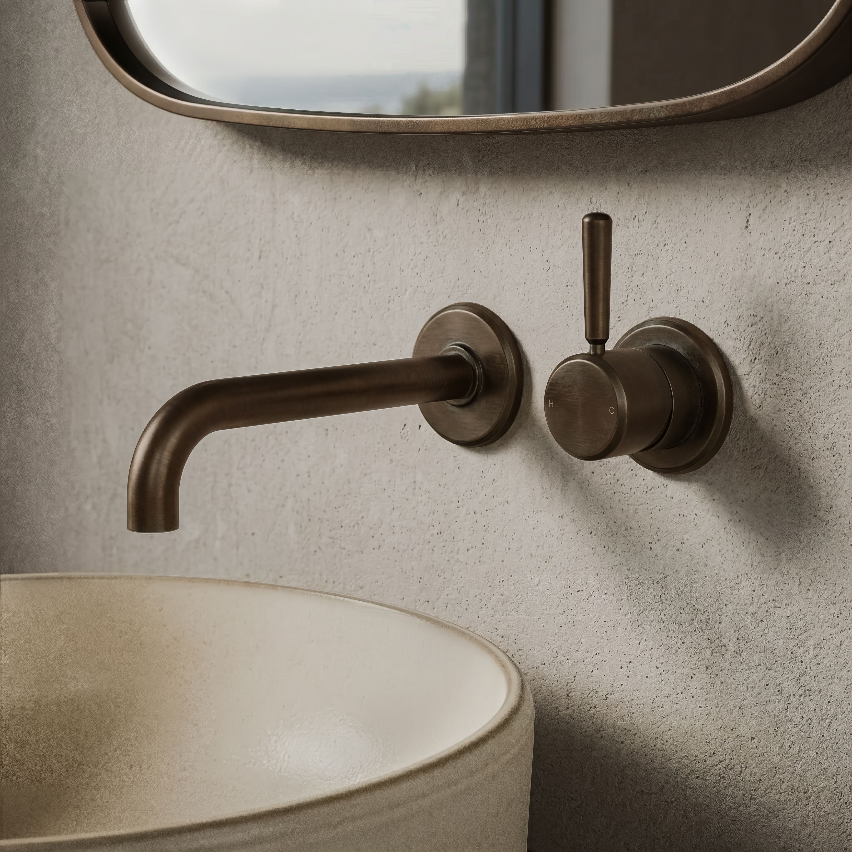 Wall-mounted mixer and spout above a stone vessel basin