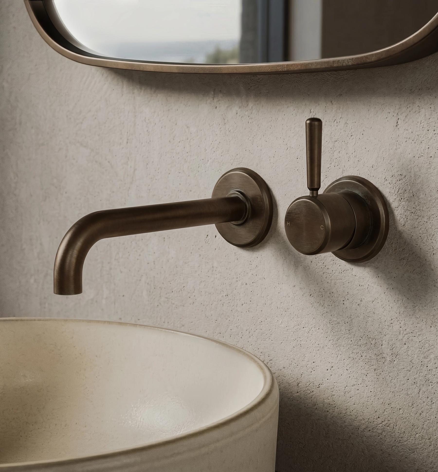 Wall-mounted mixer and spout above a stone vessel basin