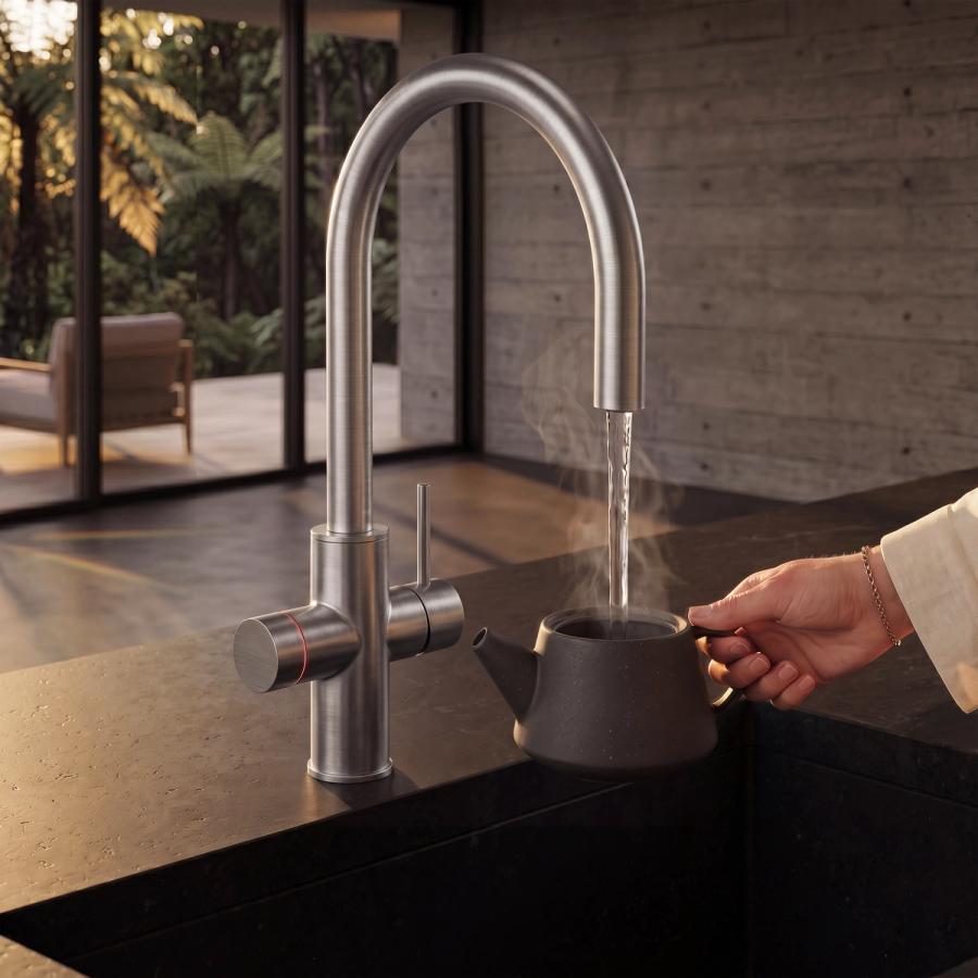 Brushed-steel multifunction boiling tap filling a ceramic teapot