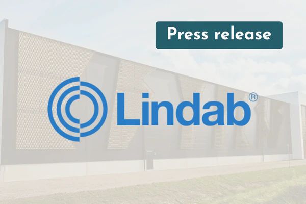 Lindab logo over a photo of an industrial building with a perforated metal façade