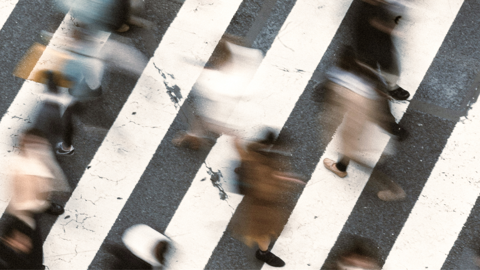 A crowd of people crossing a city street.