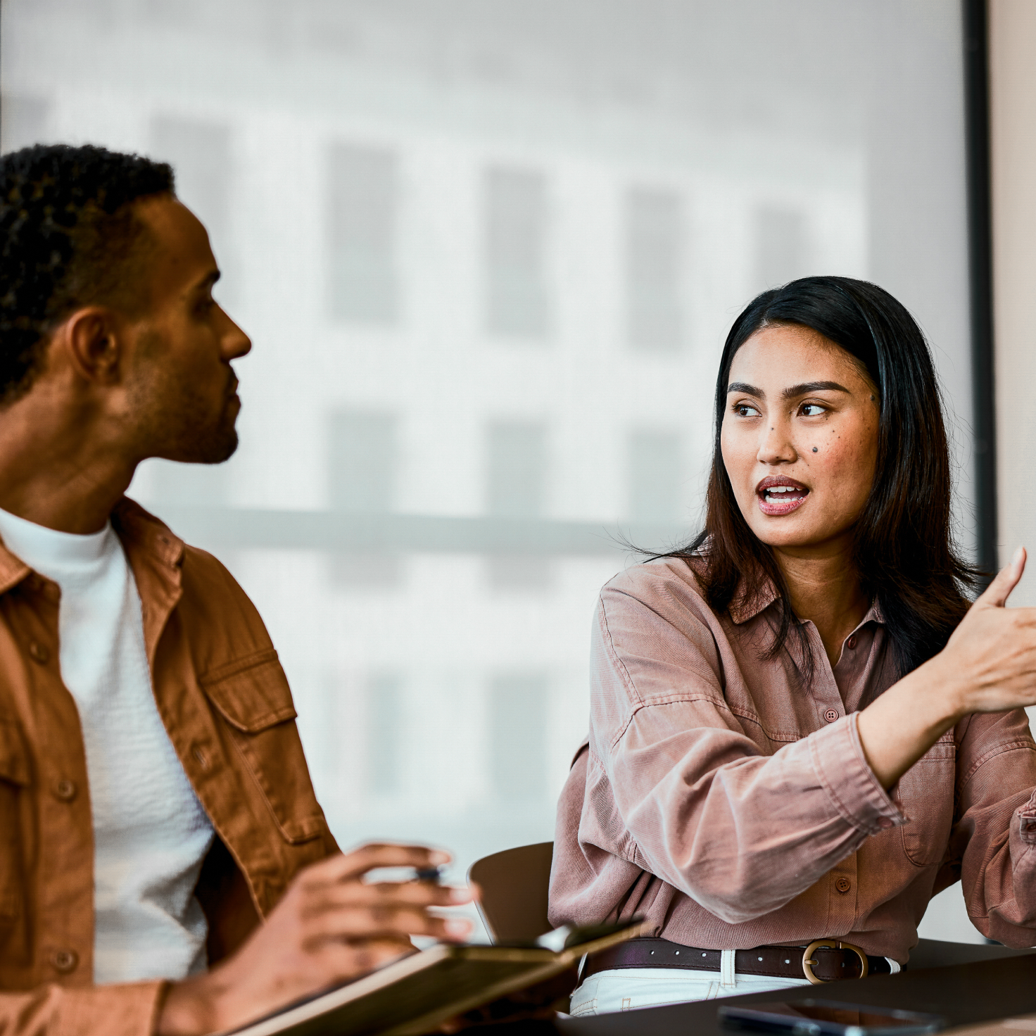 A woman speaks and gestures to a man during a discussion.