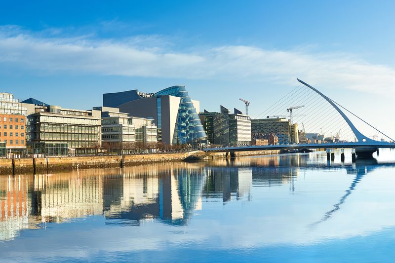Samuel Beckett Bridge and modern buildings reflected in the Liffey River, Dublin.