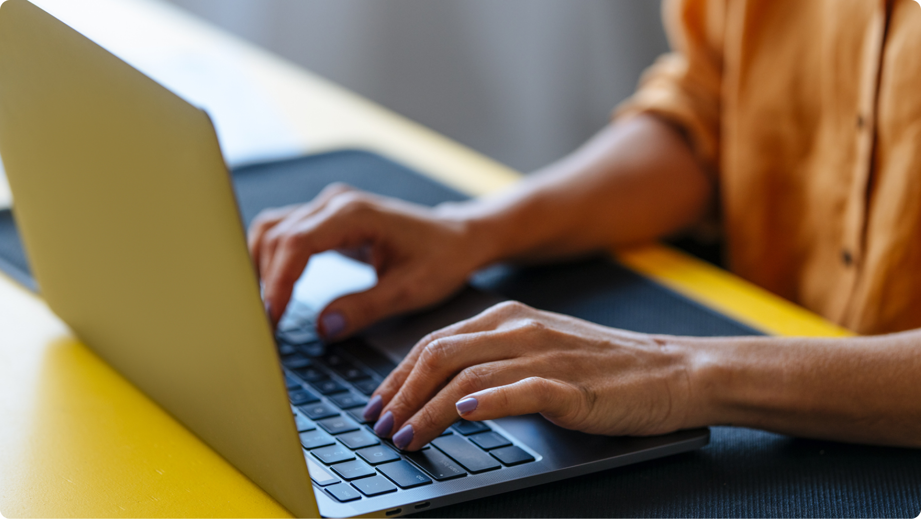 Hands typing on a laptop keyboard.