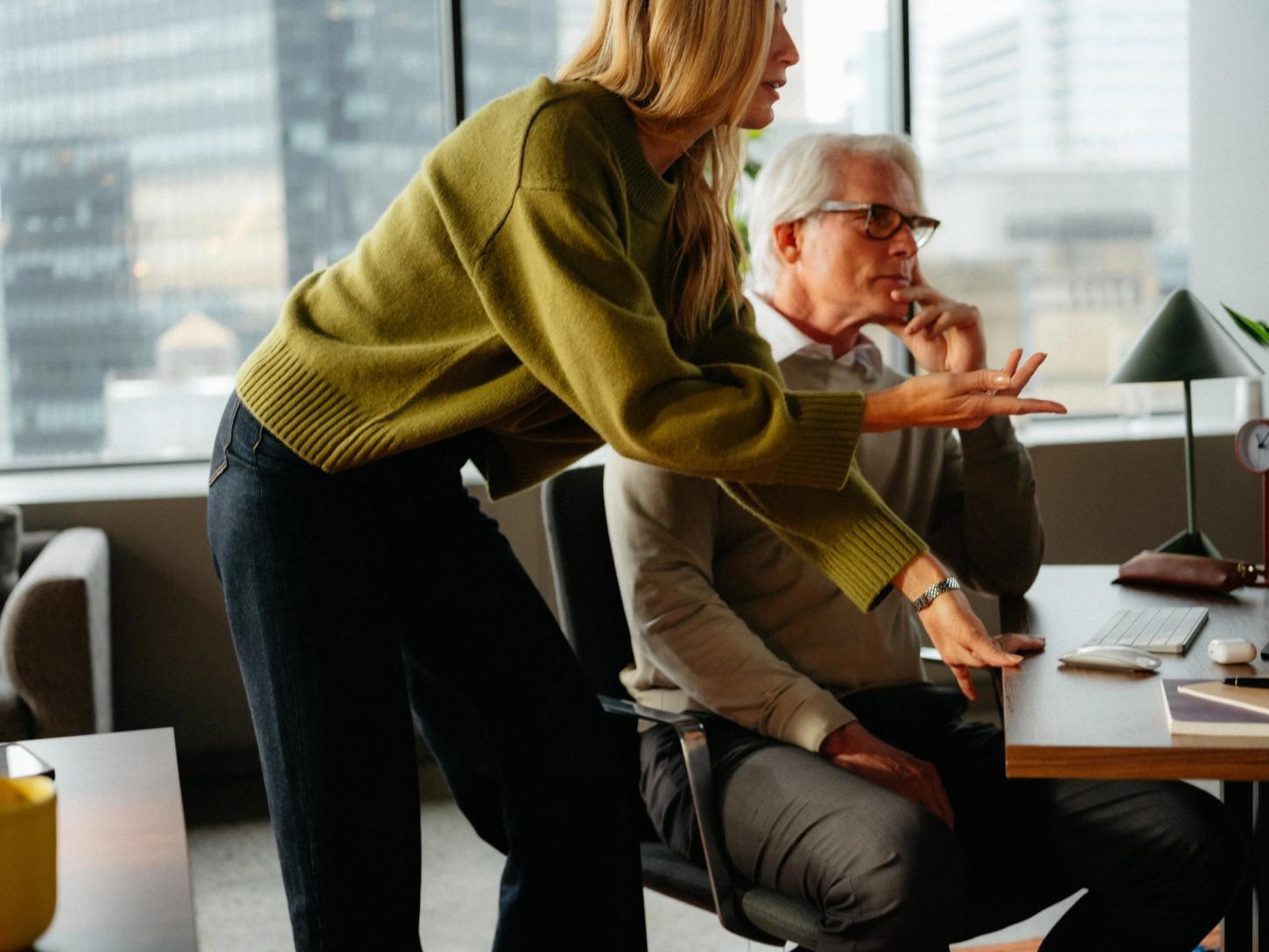 Two colleagues reviewing work together at a desk