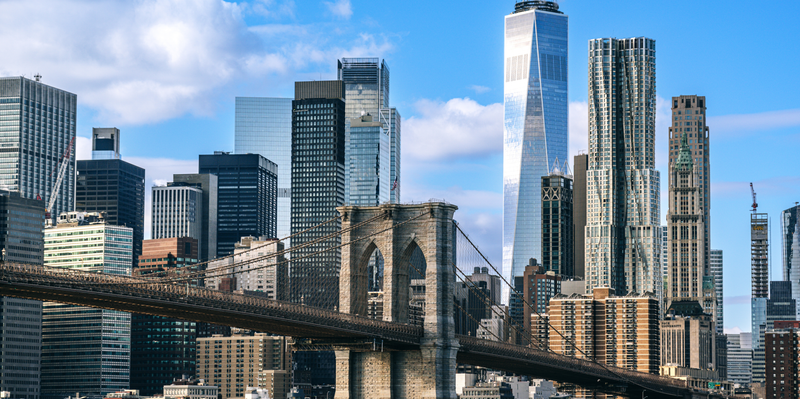 Brooklyn Bridge in front of the New York City skyline, featuring One World Trade Center.
