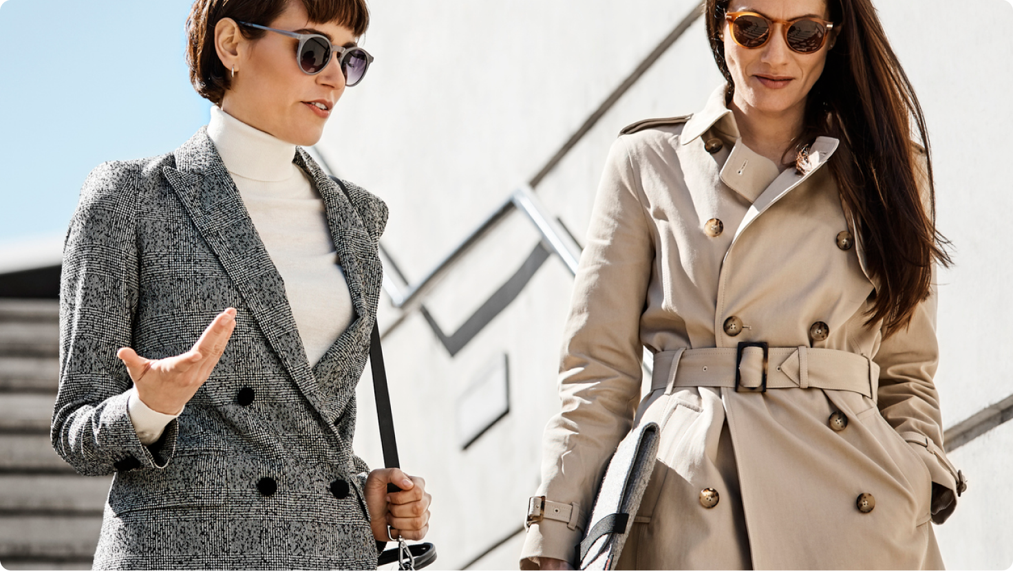 Two lawyers in professional attire talking as they walk down outdoor steps