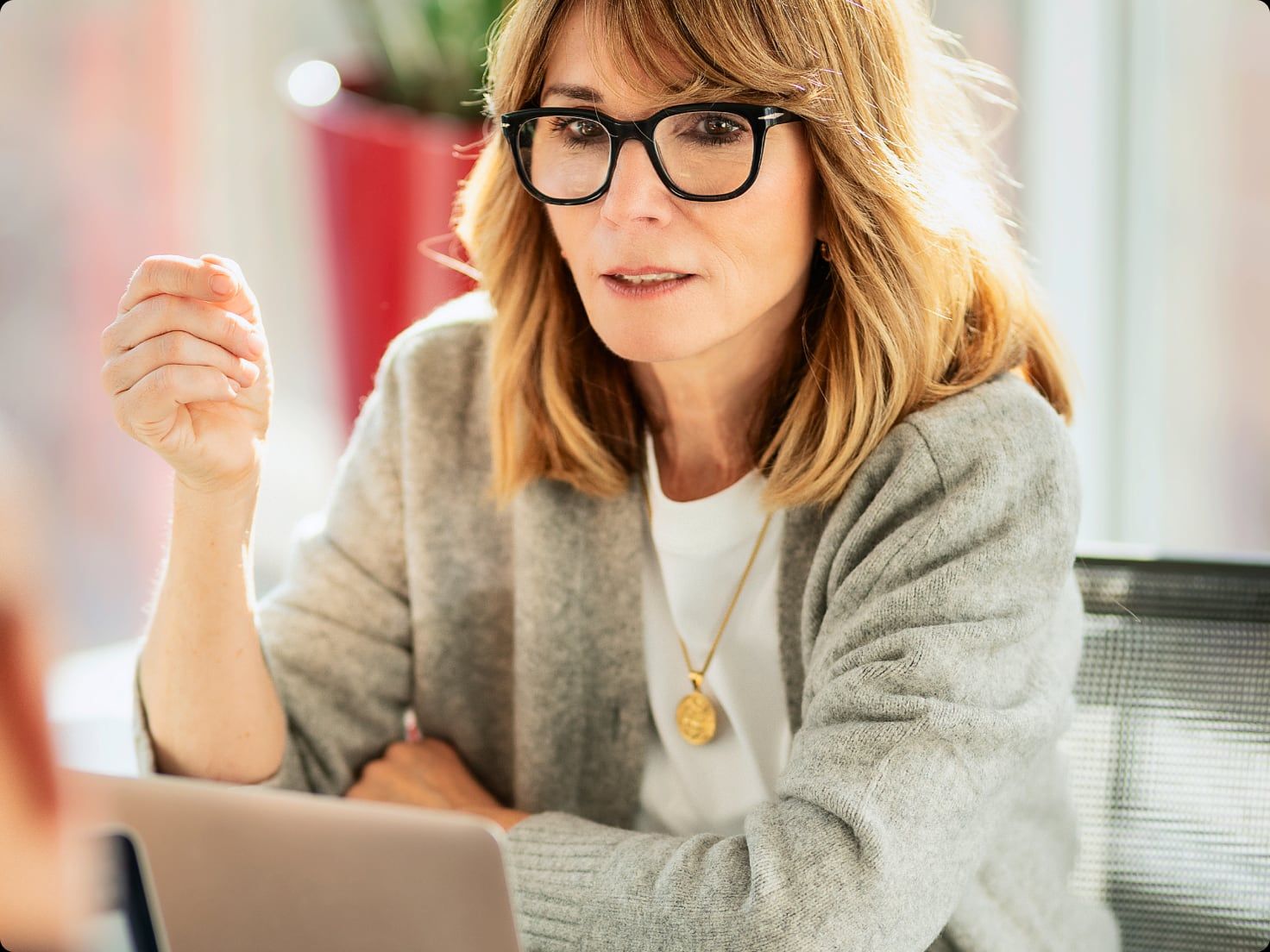 A lawyer in glasses talking through a point at her laptop.