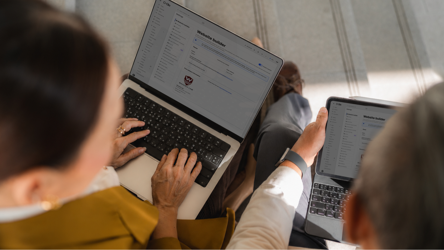 Two lawyers building a law firm website on a laptop and tablet