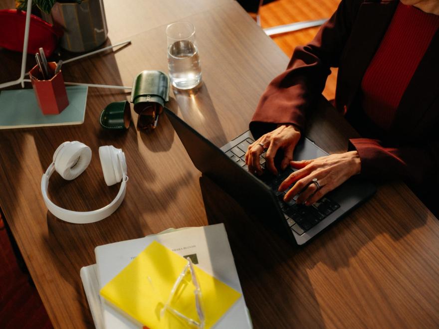 A laptop, headphones and notes on a desk