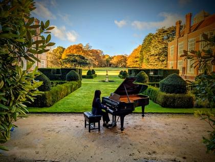 Image taken at Cobham Hall of a girl seated at a piano 