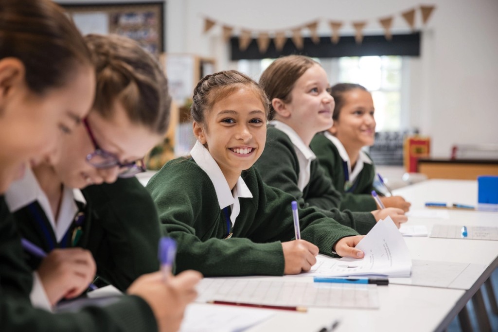 Small girl from Lyonsdown School facing camera doing school work