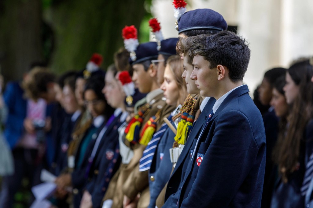 A side view of students standing outside in lines