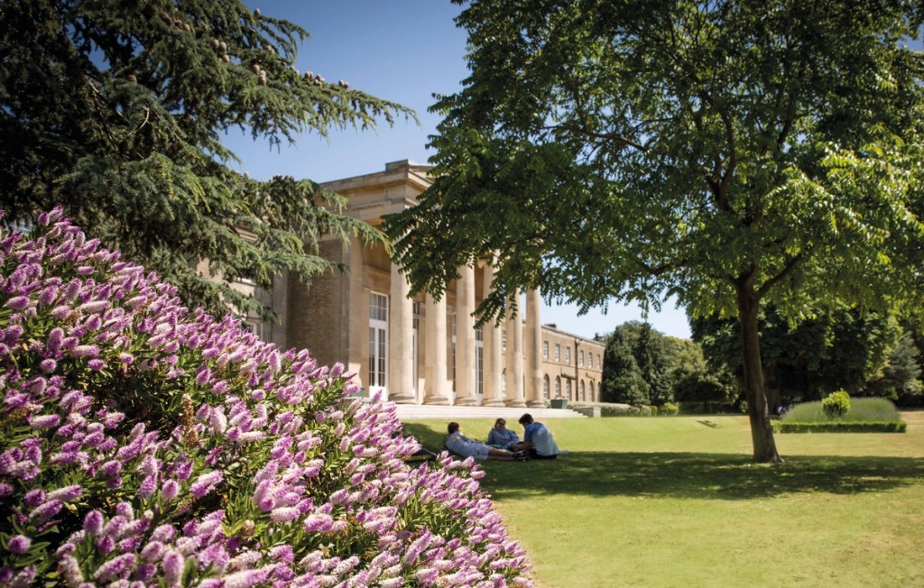 Image of Mill Hill school grounds with three people on the grass