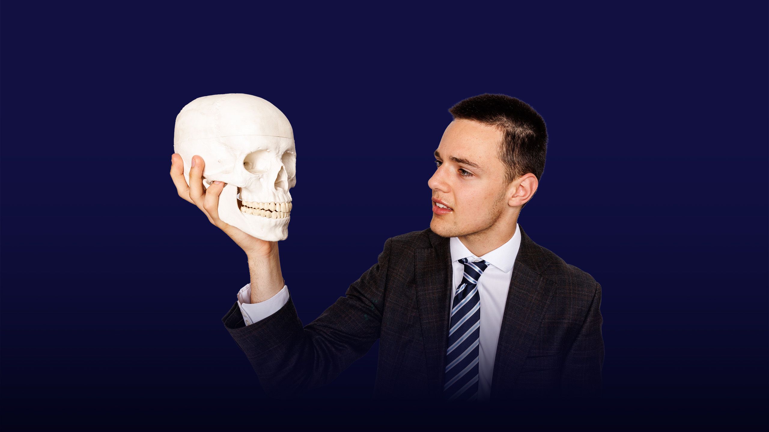 Image of a boy looking at a skeleton head he is holding with an overlay of the text "instilling values"