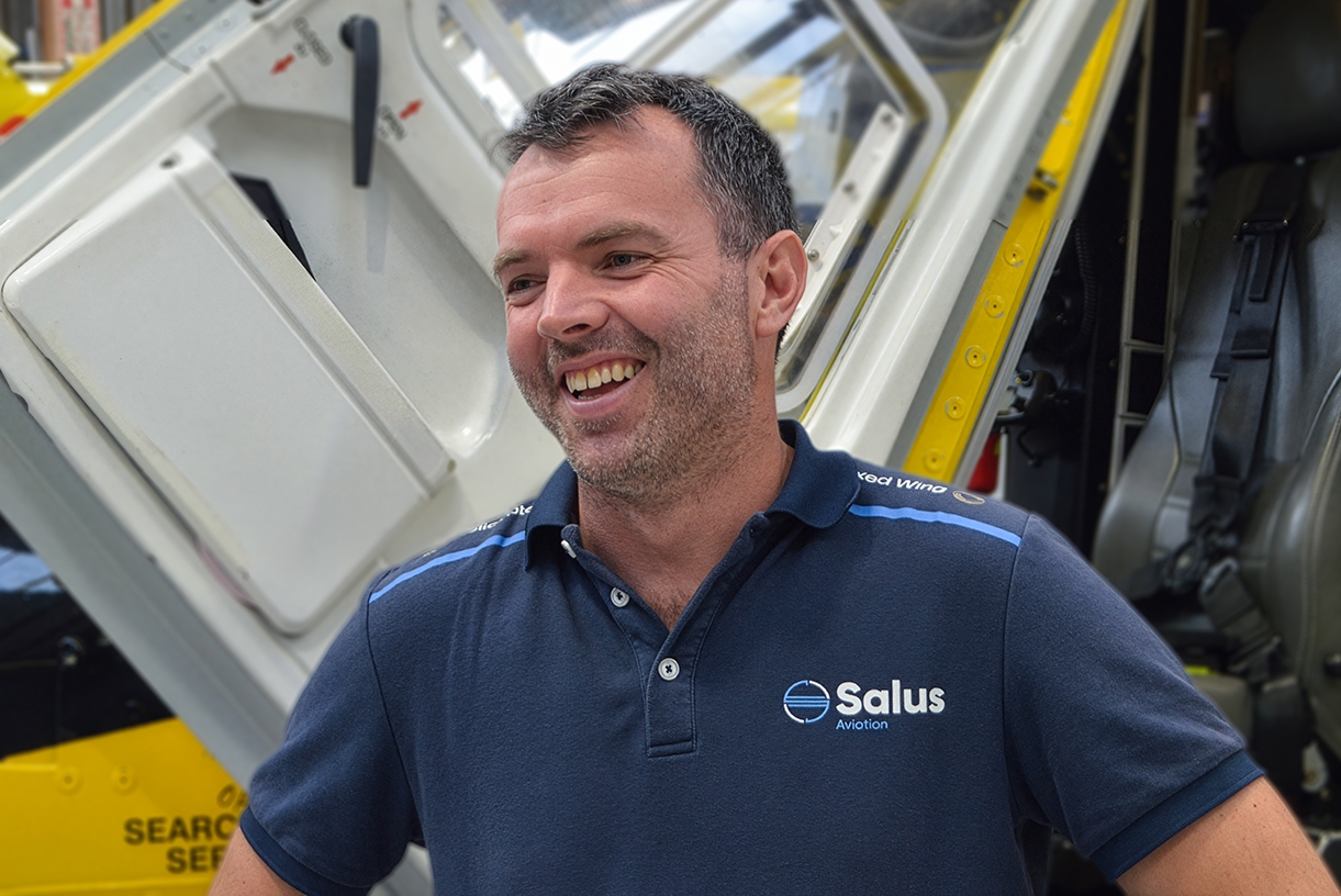 Chitty in the hangar in front of a helicopter