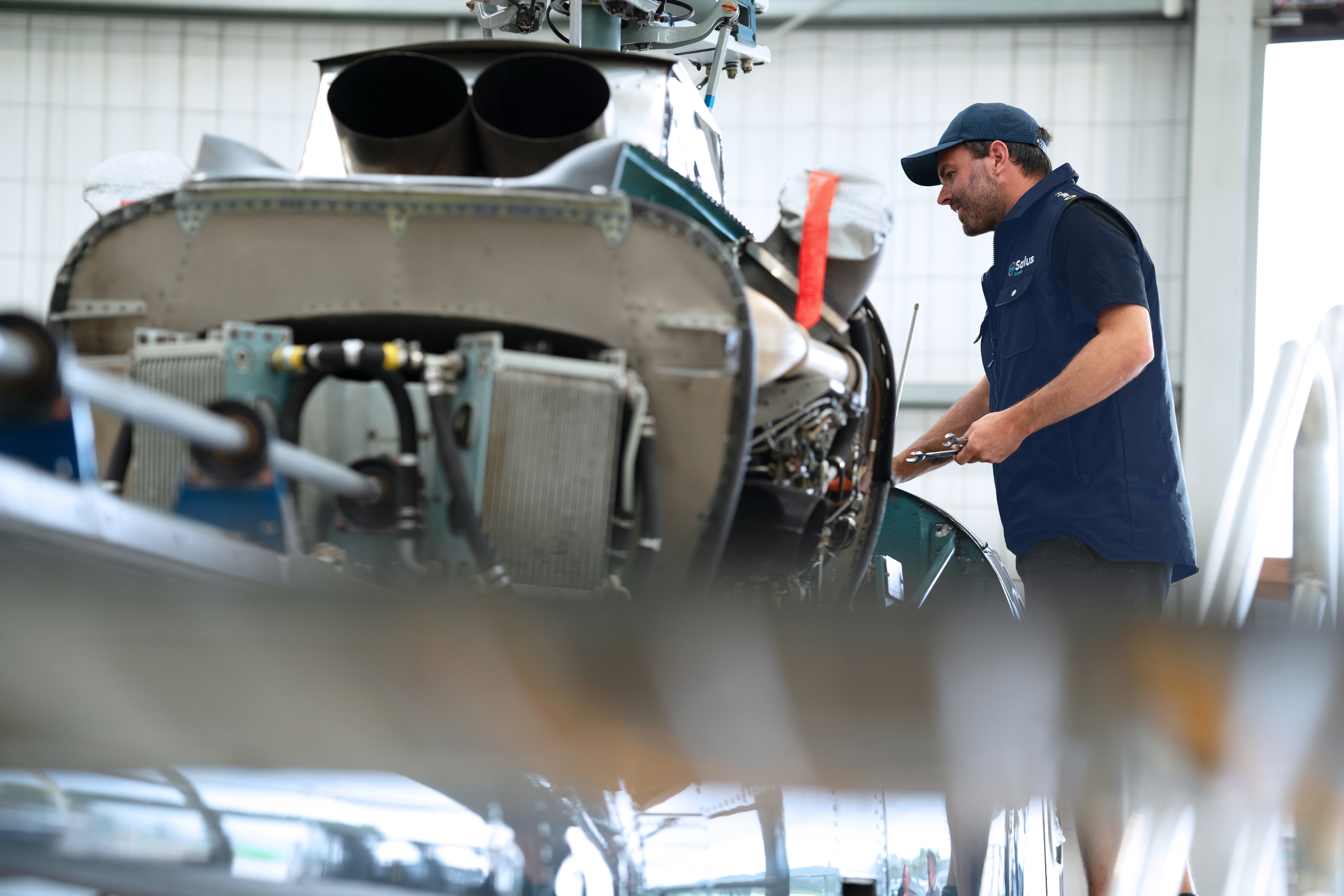 engineer working on helicopter in hangar