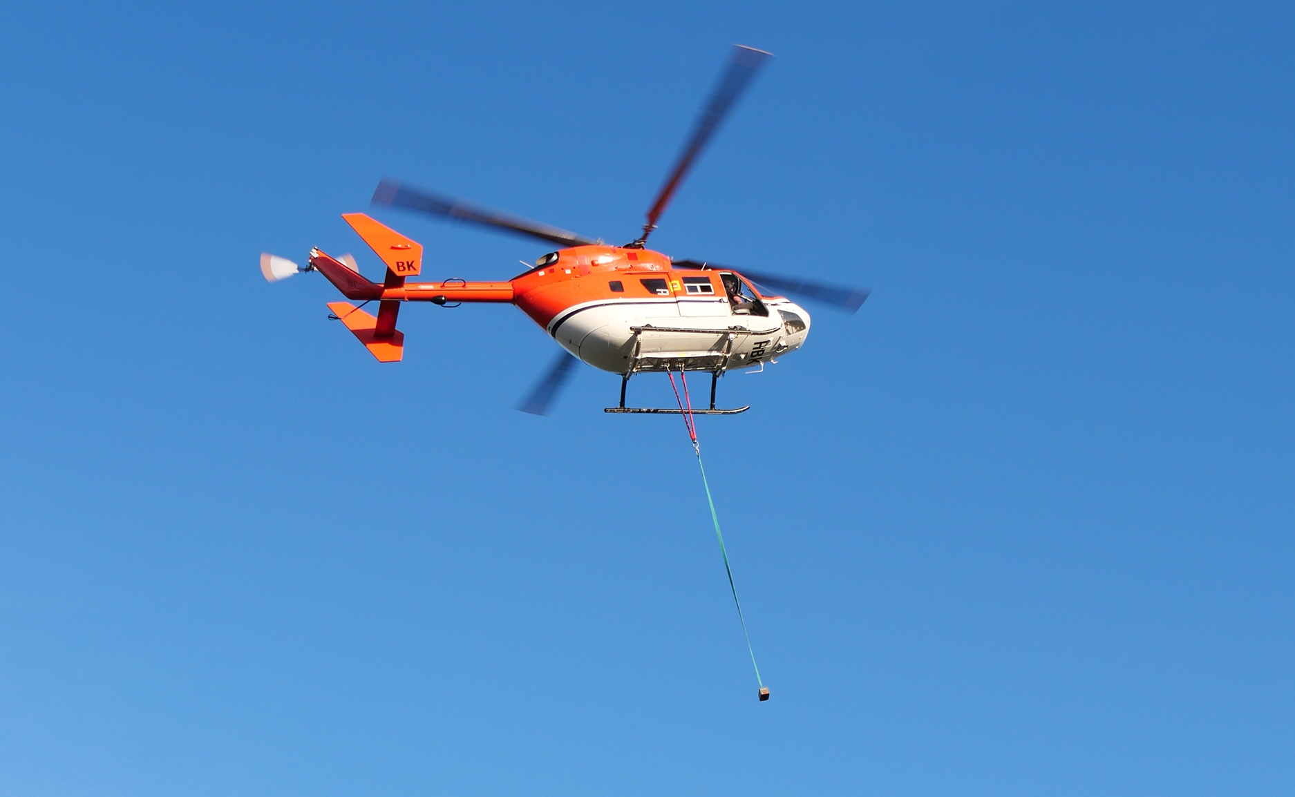 BK117 helicopter flying with HEC Dual Hook in use