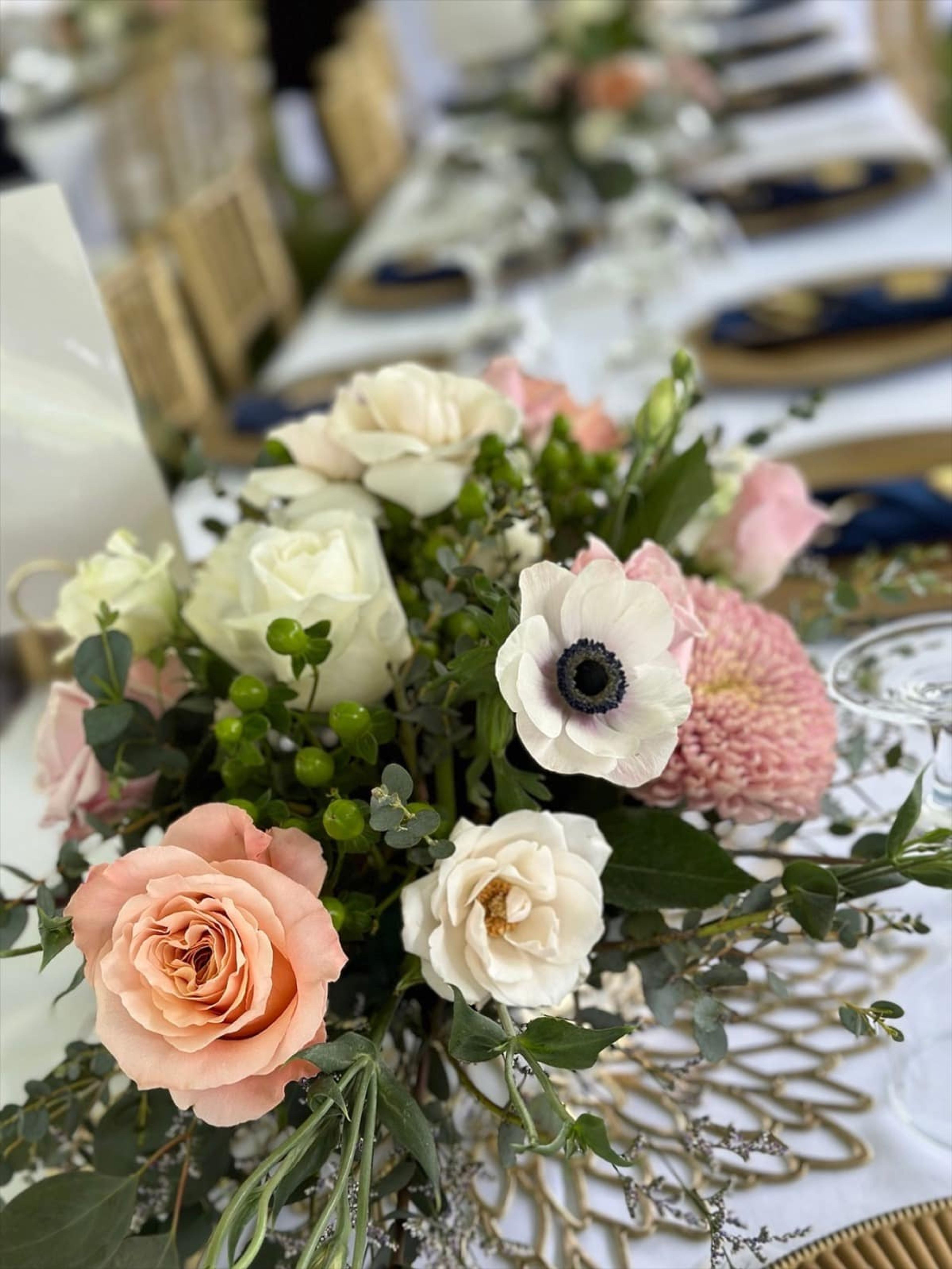 Blush, ivory, and green wedding centerpiece on an elegant reception table