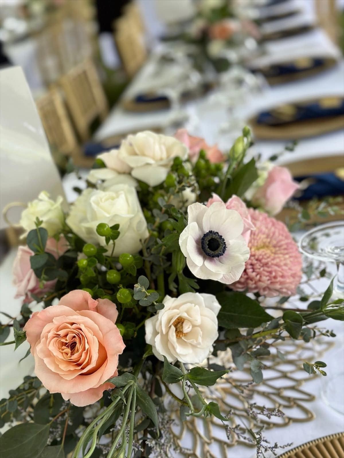Blush, ivory, and green wedding centerpiece on an elegant reception table